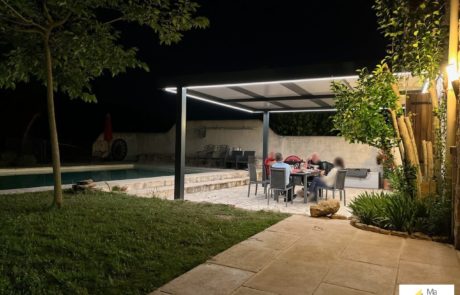 Jolie maison en pierre avec pergola éclairée sur terrasse