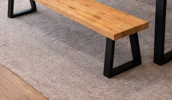 Swedish pine bench with black metal trapezoid legs in modern dining room