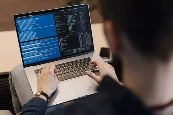 Concentrated coder working on programming tasks in a cozy, modern workspace.