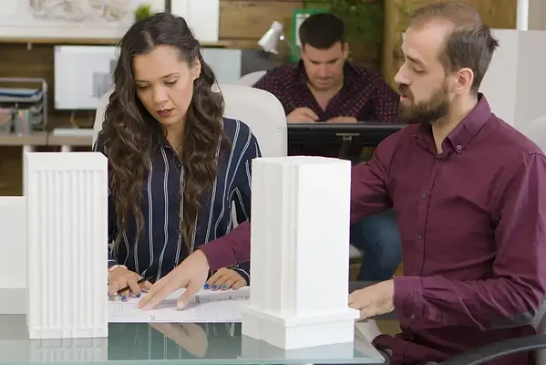 Creative teamwork in a modern workspace with architectural models and focused collaboration.