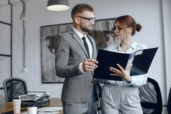 Professional teamwork in a modern office as two individuals discuss important documents.