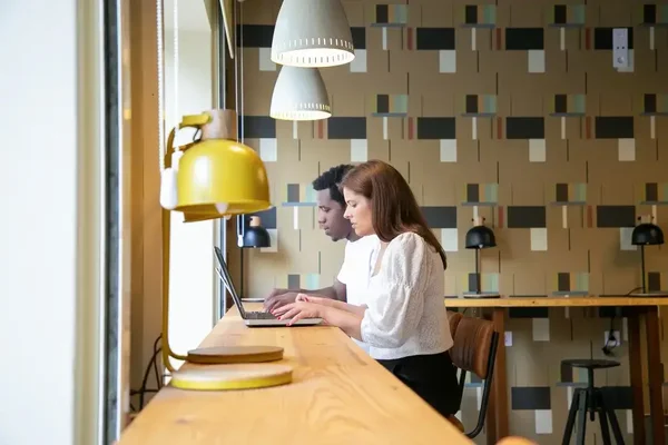 Collaborative workspace in a bright café, featuring modern design and natural light.