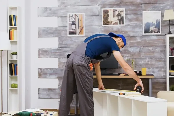 DIY enthusiast assembles furniture in a bright, stylish living room with modern decor.