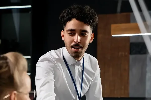 Professional discussion between a man and woman in a sleek, modern office setting.