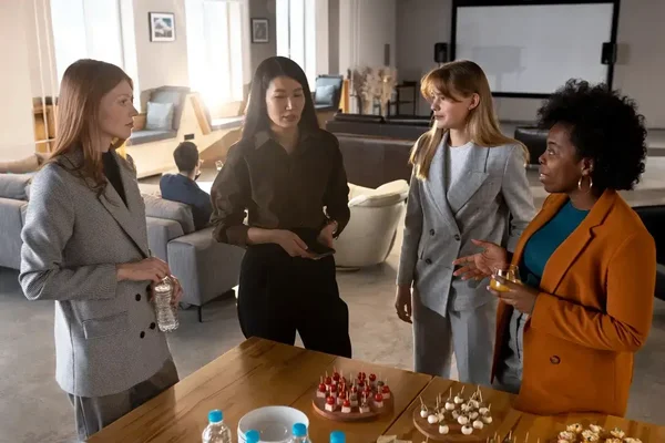 Women networking and collaborating in a bright, modern office with refreshments and inspiration.