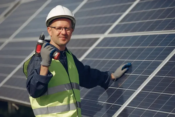 Technician maintaining solar panels under sunlight, promoting efficiency and sustainability in renewable energy.