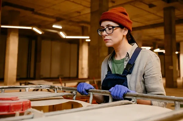 Determined woman working in an industrial space, embodying creativity and hands-on strength.