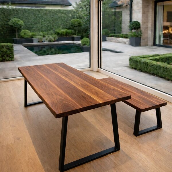 Handcrafted solid walnut dining table with live edge and matching bench in contemporary home