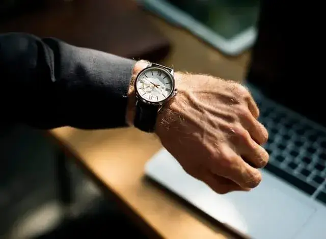 Elegant watch and laptop in a modern workspace, blending style and productivity.