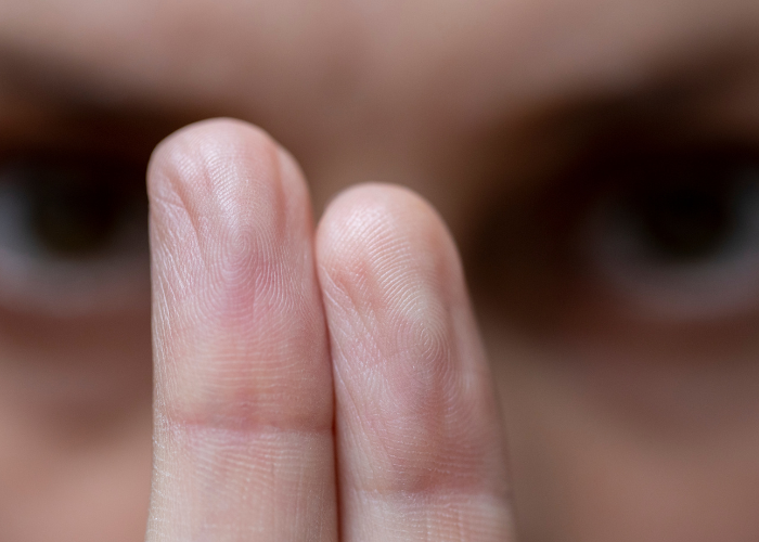 A woman with her fingers raised, representing a moment of clarity in the discussion of EMDR versus Talk Therapy for trauma.