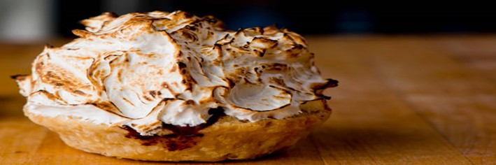 Homemade Baked Alaska Its the Bomb featured image 200x600w baked alaska on wooden surface frosted fusions