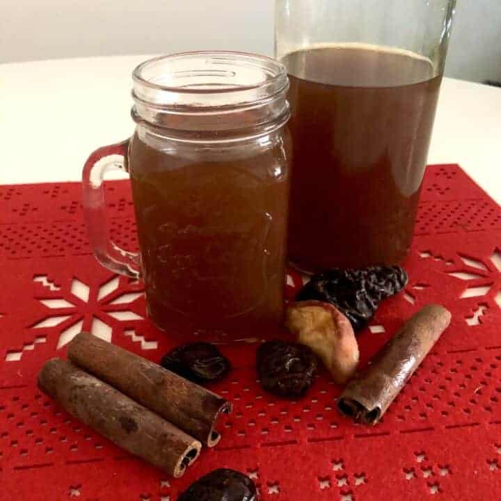 Traditional Polish Christmas drink recipe for Kompot z suszu, featuring a jar of mulled cider infused with cinnamon sticks.