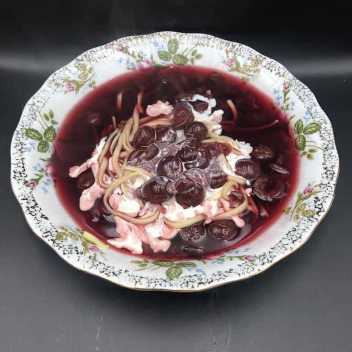 A bowl of traditional Polish soup with cherries and sour cream.