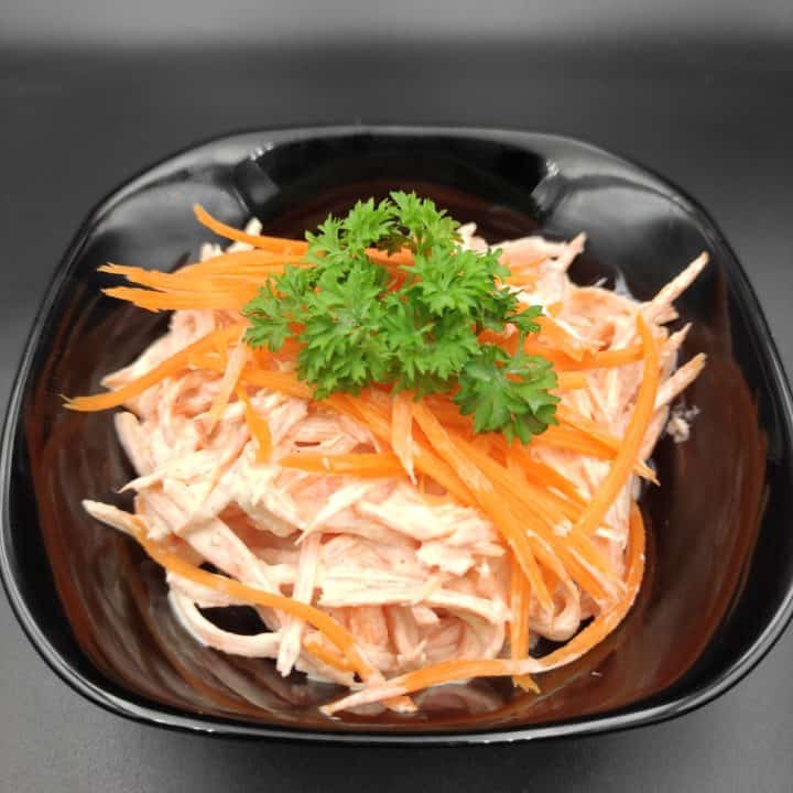 Polish surowka z marchewki polish carrot salad in a black bowl.