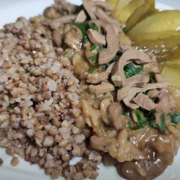 A plate with rice and pickles on it, served alongside a Polish pork kidney recipe.