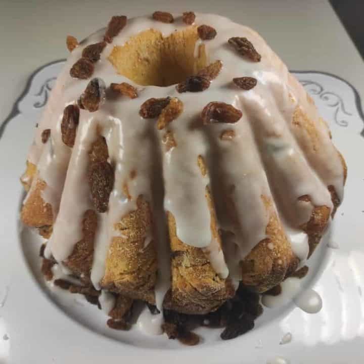 Babka drozdzowa topped with glaze and raisins.