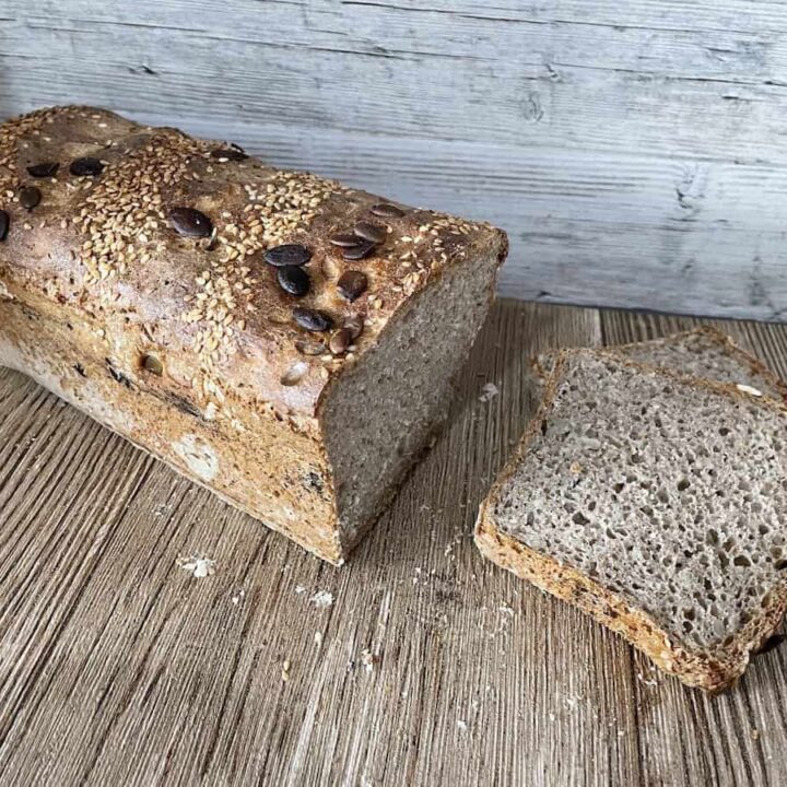 A loaf of Polish sourdough multigrain bread sitting on a wooden table.