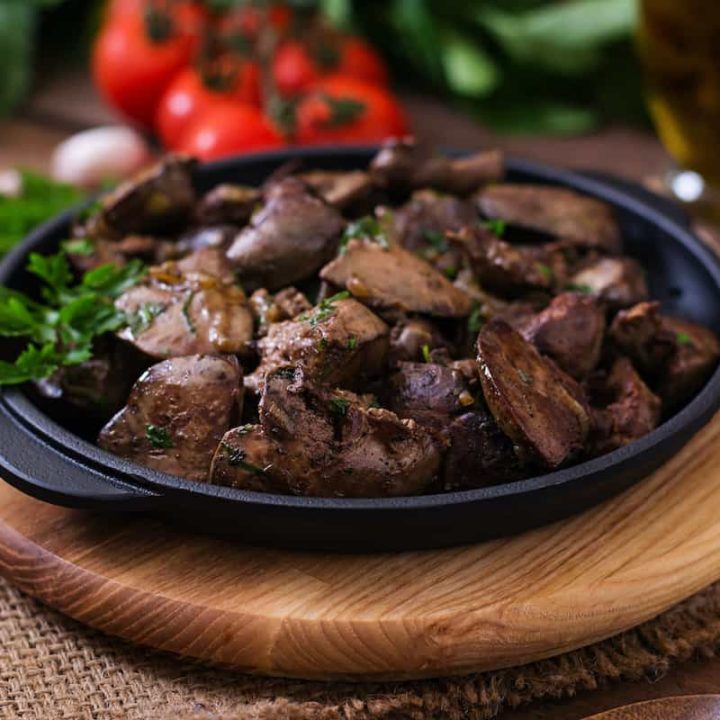 Polish chicken liver recipe served in a black bowl on a wooden table.