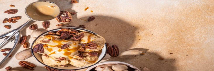 Easy-Homemade-Brown-Butter-Pecan-Ice-Cream-featured-image-207x620w-cropped-bowl-of-brown-butter-pecan-ice-cream-with-caramel-sauce-drizzled-silver-scoop-and-nuts-scattered-frosted-fusions