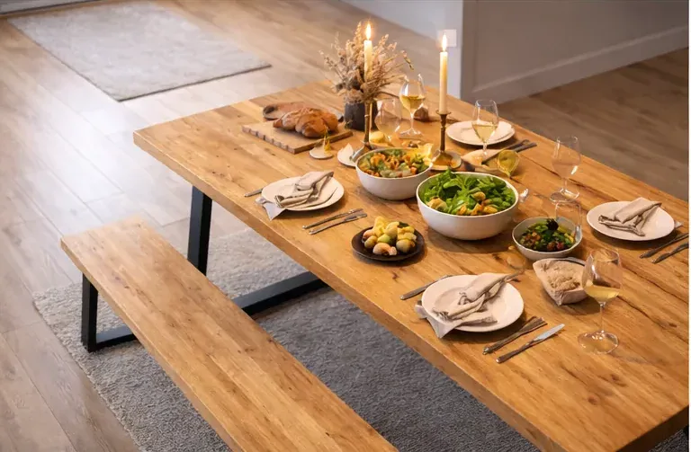 Top view of Swedish pine dining table set for evening meal with candles and tableware
