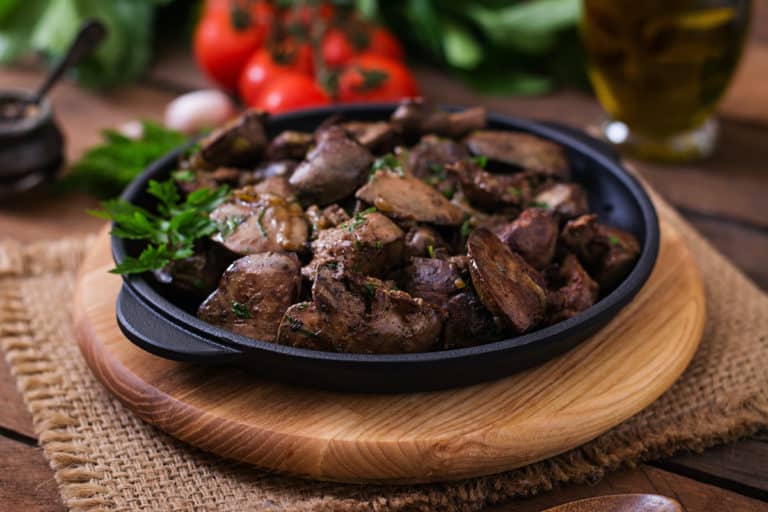 Polish chicken liver recipe served in a black bowl on a wooden table.