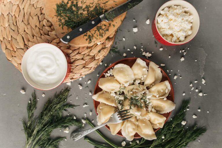 A plate of Polish dumplings with dill and herbs on a gray background, perfect for New Year's Eve.