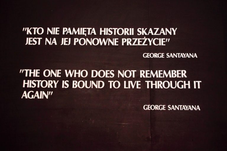 A black background displays George Santayana's quote in Polish and English: “The one who does not remember history is bound to live through it again.” Perfect inspiration for off the beaten path holidays exploring Poland's best places to see.
