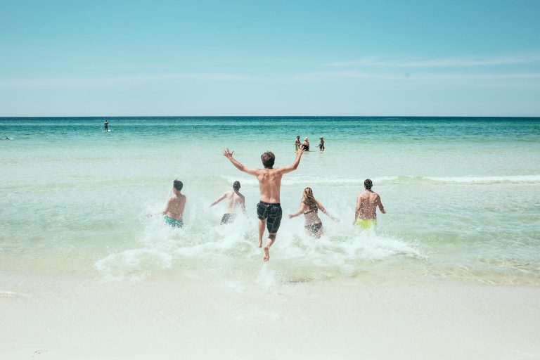 famille qui plonge dans la mer depuis une plage