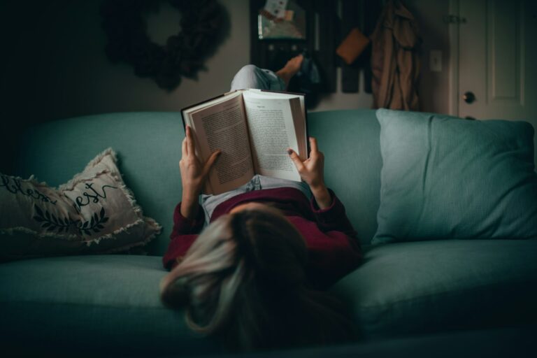 Personne qui lit un livre sur un canapé