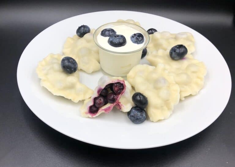 blueberyy pierogies on a white plate.