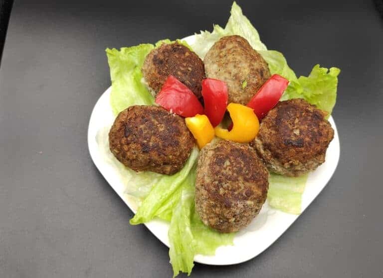 Polish Meatballs on a plate with lettuce and peppers.
