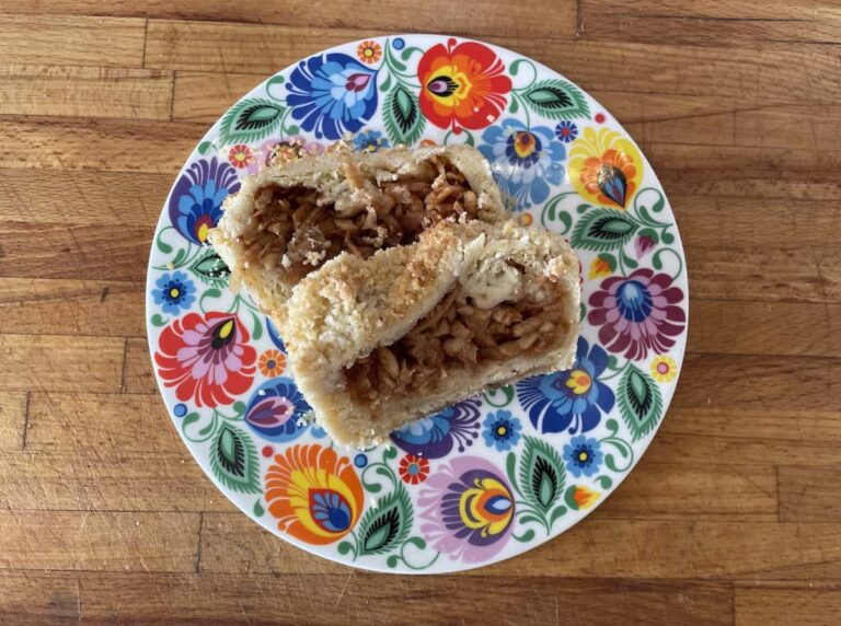 A plate with a piece of apple pie on it, drizzled with apple cinnamon.