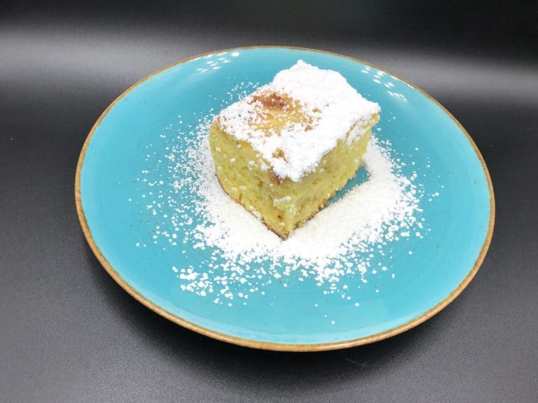 A Fluffy Sponge Cake with powdered sugar on a blue plate.