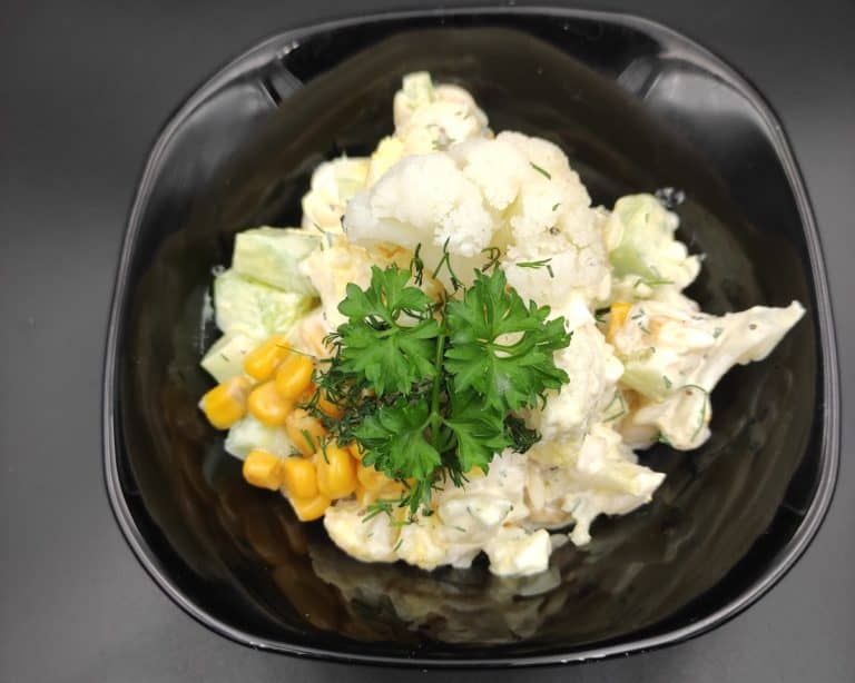 sałatka z kalafiora polish cauliflower salad in a black bowl.