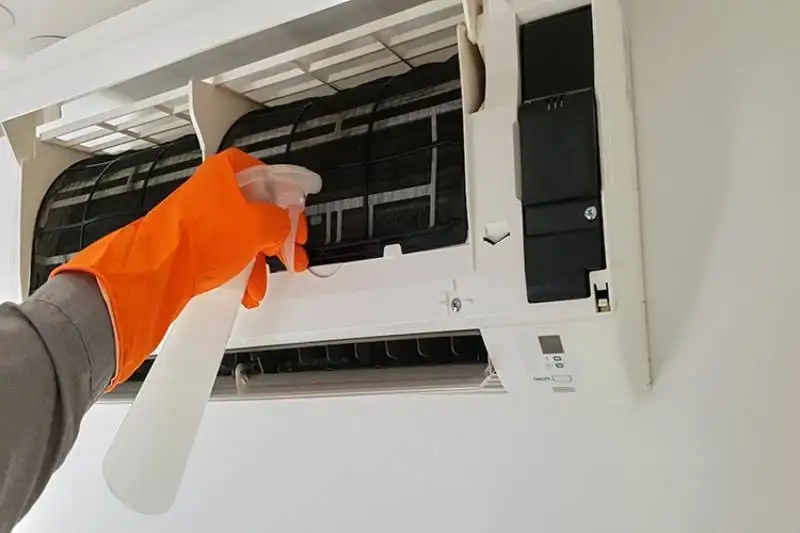 Modern air conditioner unit service cleaning the filter to prevent respiratory disease.