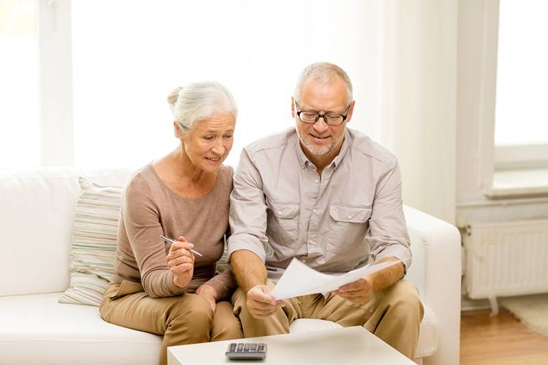 elderly couple looking over a bill