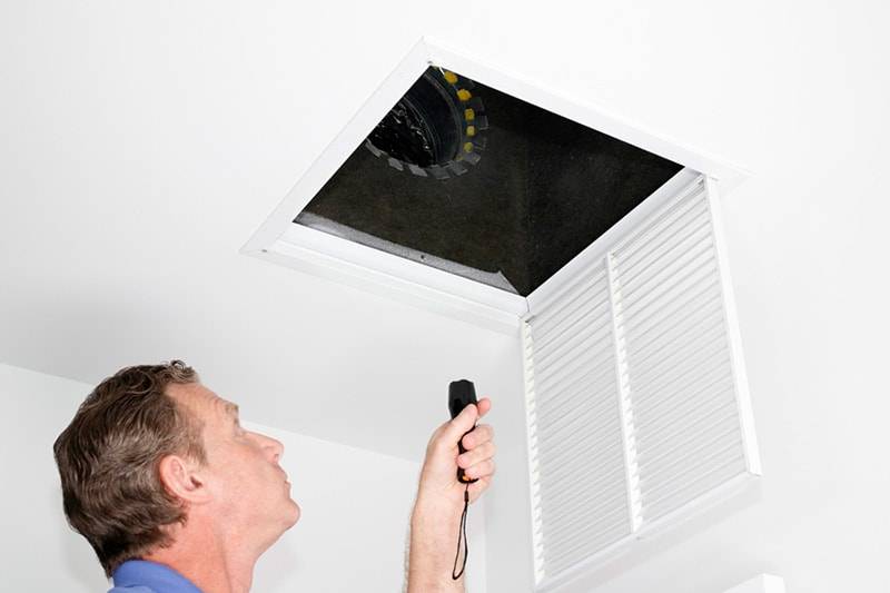 Man Inspecting HVAC System