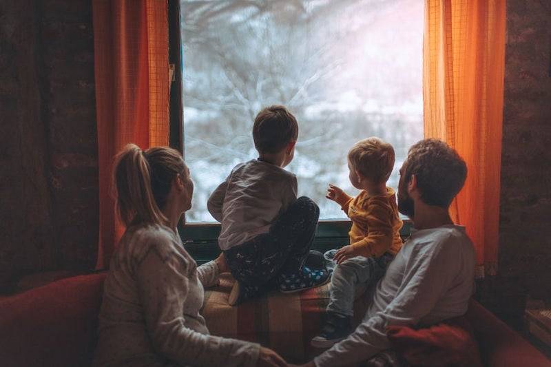 family looking out window in winter