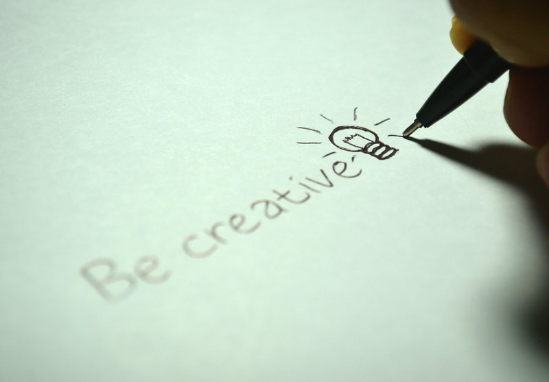 Una penna che scrive le parole "sii creativo".
