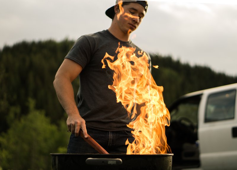 Homme cuisinant sur un feu. Métaphore des méthodes d'approche commerciale qui permettent de réchauffer les prospects.