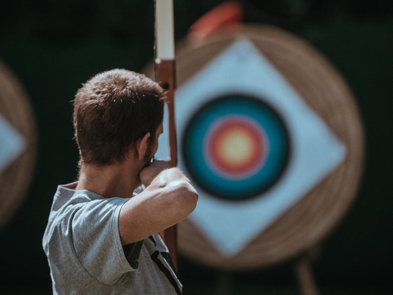 un homme qui vise un œil de bœuf, métaphore d'un marché cible