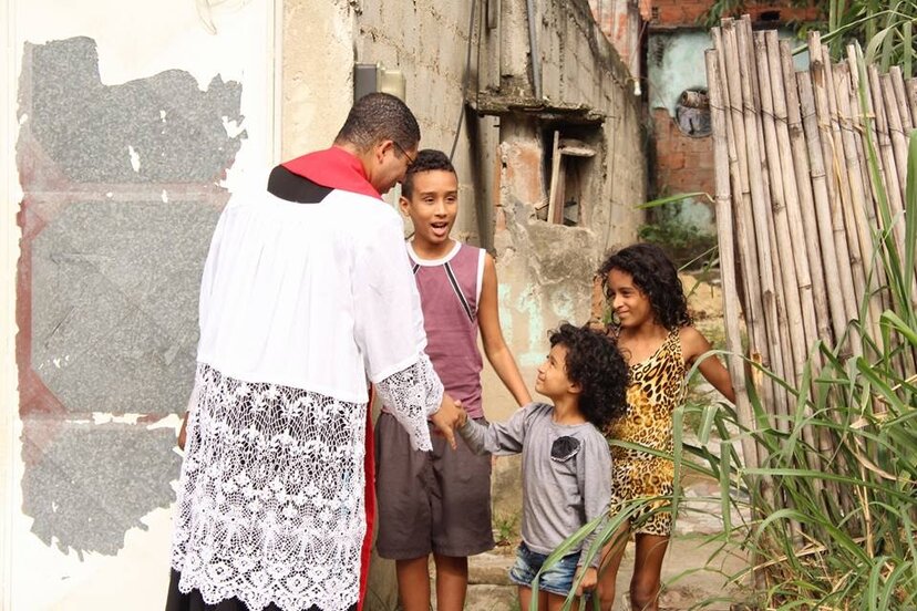 El P. Douglas saludando a niños de las periferias.