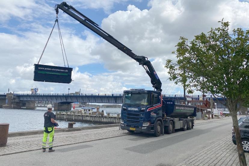 Kranbil fra Anker Christensen l&oslash;fter en container ved havnen