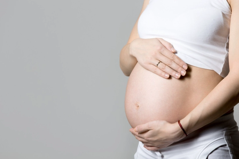 schwangere frau, die ihren bauch berührt