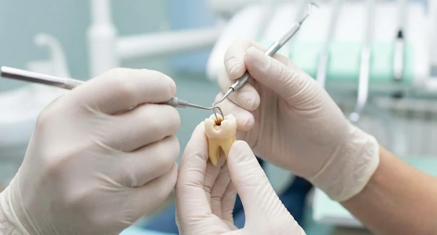 tandl&auml;kare som behandlar en mj&ouml;lktand p&aring; klinik