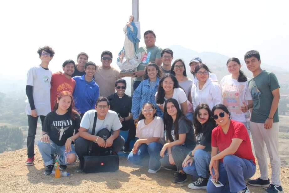 Un grupo de j&oacute;venes durante una peregrinaci&oacute;n mariana posan felizes en la cima de una monta&ntilde;a. 