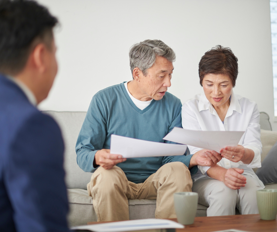 Senior married couple reviewing documents with an attorney, discussing a Florida Community Property Trust as part of their estate plan