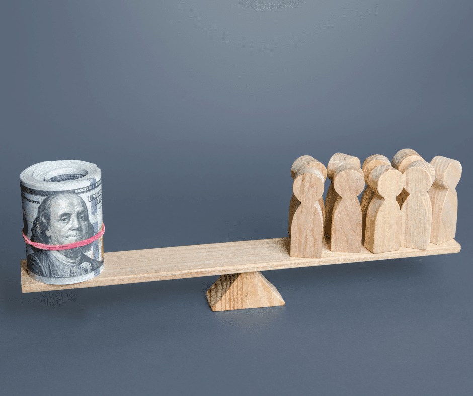 A board on a pendulum with a roll of money on one side and wooden people on the other