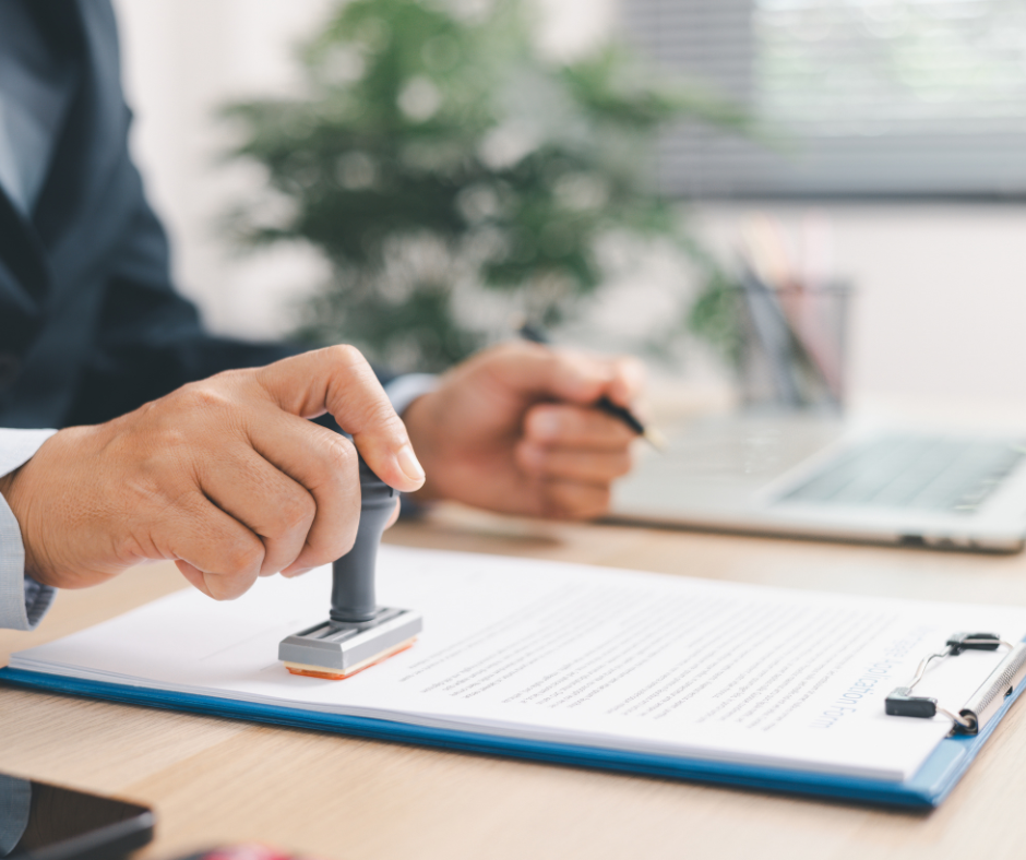 Man sitting at desk stamping a document
