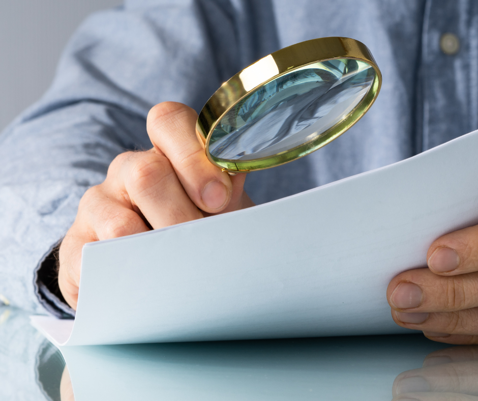 Man reviewing a document with a magnify glass